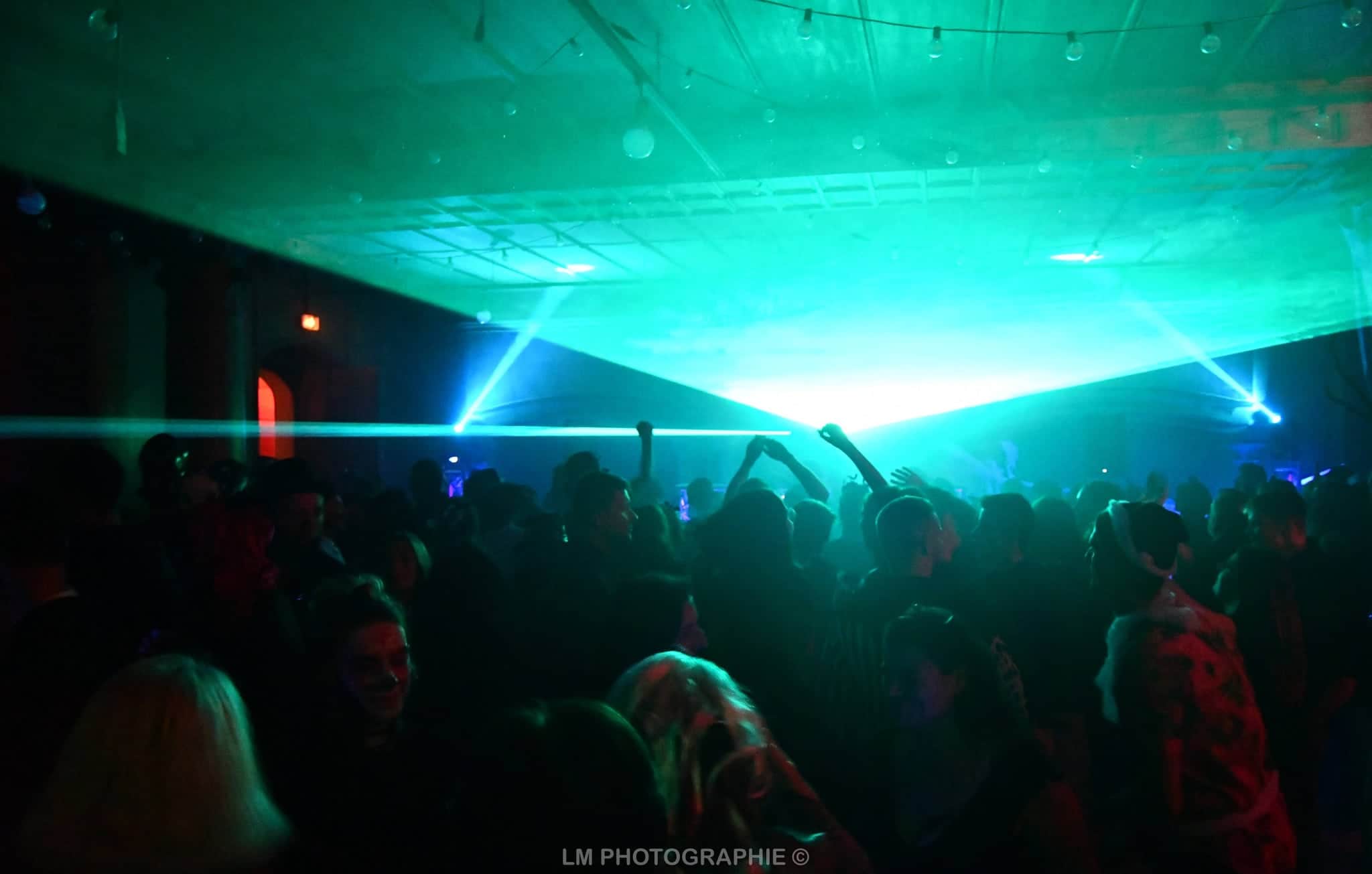 Foule sous le plafond de lasers — bal animé par DJ Deelight Evolution